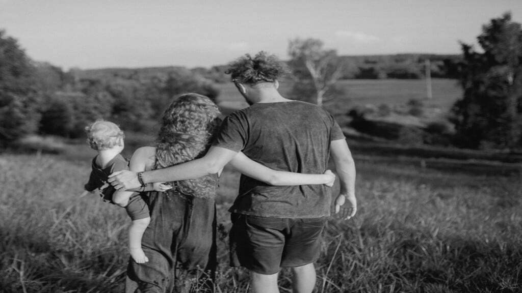 Back View of a Family Walking on the Green Grass
